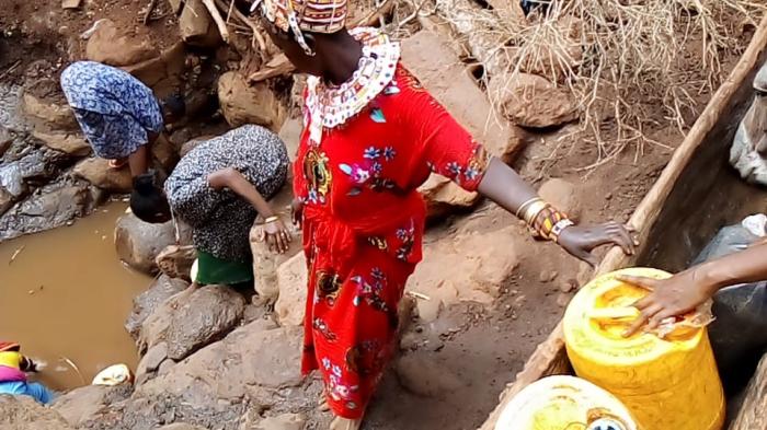 Samburu women collecting water from a water well